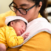 A parent holds their baby in the NICU.