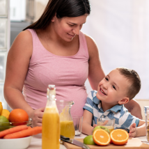 A pregnant person prepares food in a home kitchen to help prevent anemia during pregnancy.