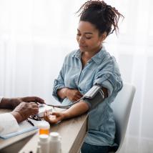 A doctor measures a pregnant person's blood pressure.