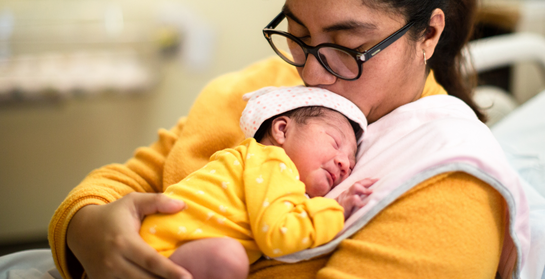 A parent holds their baby in the NICU.